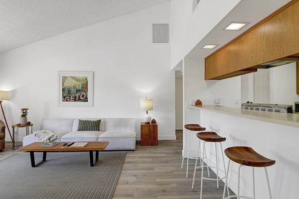 Your bright open-concept space features vaulted ceilings and a sleek breakfast bar with modern bar seating, perfect for morning coffee or casual meals.