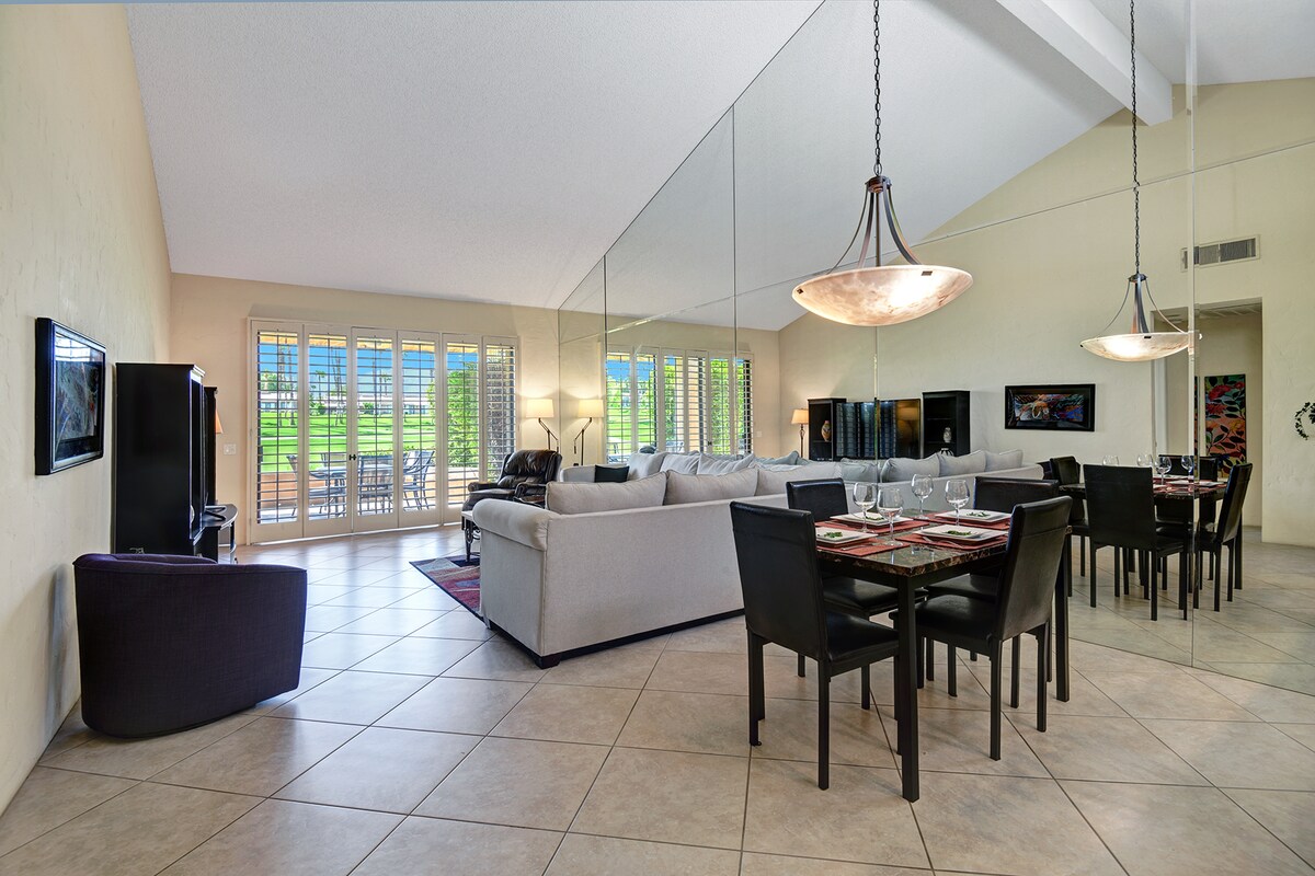 Step into this open, light-filled living and dining space where soaring ceilings and warm natural light create an inviting atmosphere. Your retreat opens to greenery through elegant shuttered doors.