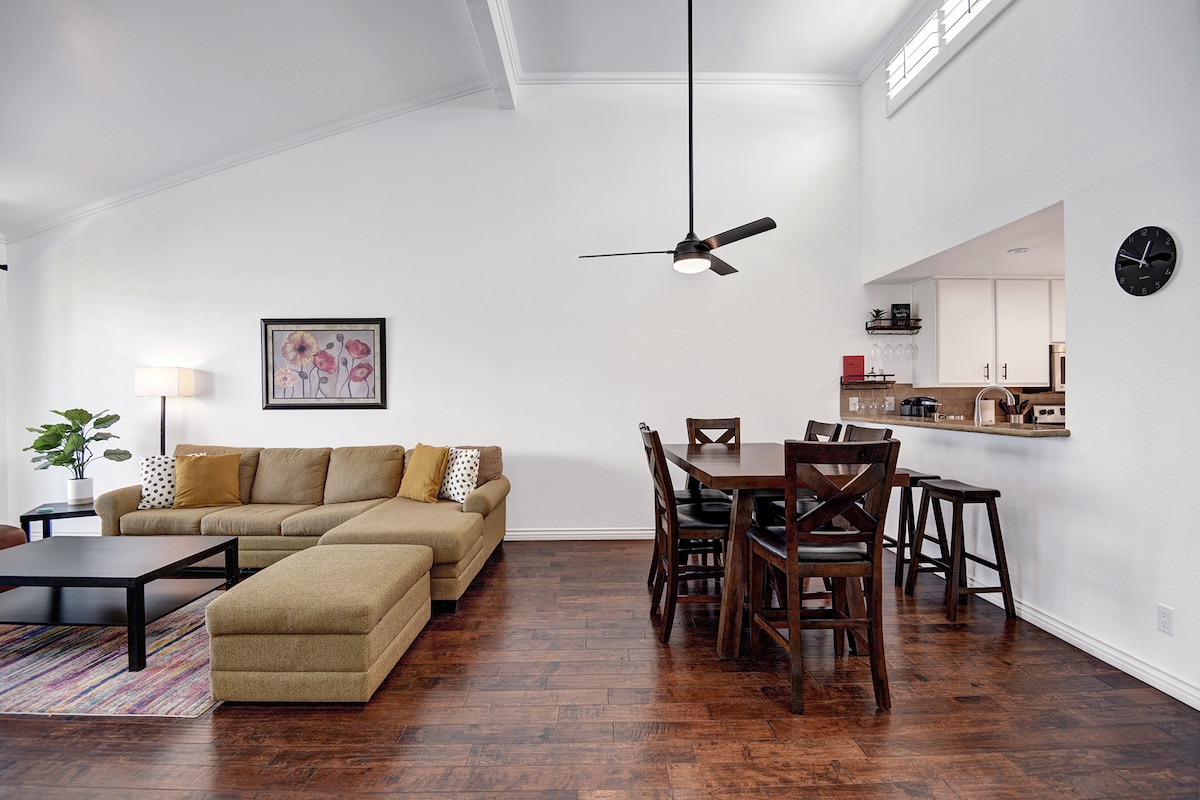 Settle into your bright, open living space where soaring vaulted ceilings and warm hardwood floors create an inviting atmosphere for relaxing together after a day of exploring.