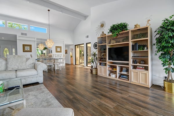 You'll love relaxing in this bright, airy living space with its vaulted ceilings and warm hardwood floors. Sunshine pours through high windows while you unwind on plush seating or gather for meals in the adjoining dining area.
