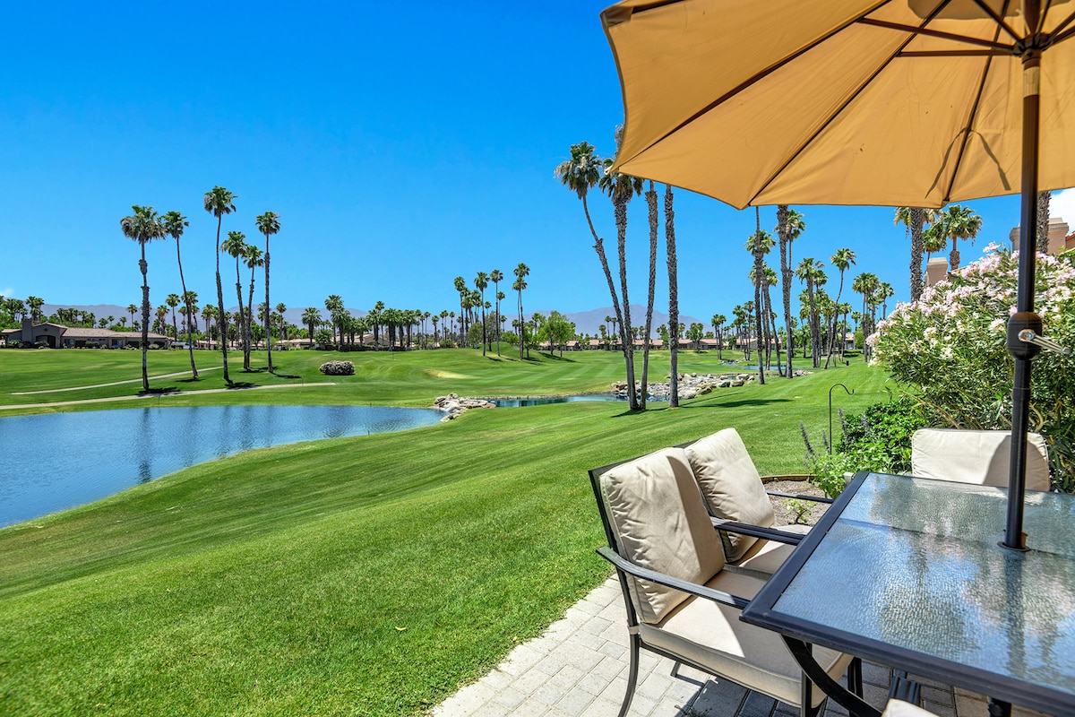 This sun-drenched patio overlooks a pristine golf course framed by swaying palms and a tranquil pond—perfect for sipping your morning coffee as the desert mountains rise in the distance.