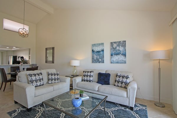 Sink into plush sofas in your airy living room, where vaulted ceilings and soft lighting create a warm, welcoming retreat perfect for unwinding after exploring the area.