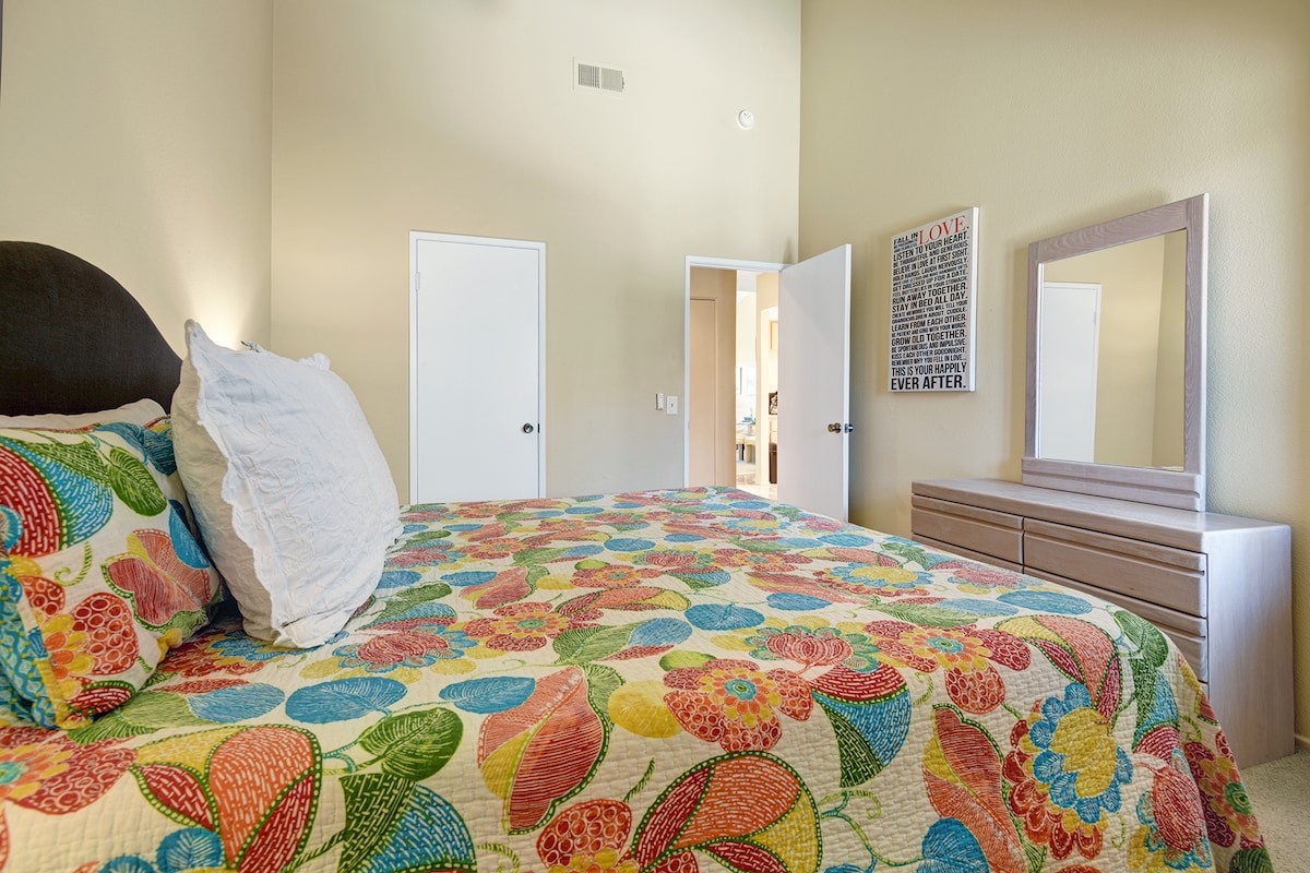 Sink into restful sleep surrounded by cheerful colors and calming comfort. This private retreat features a plush queen bed, tall ceilings for an airy atmosphere, and a convenient en-suite bathroom.