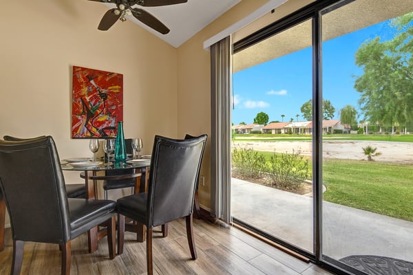 Step into your private dining nook where sunshine streams through glass doors opening to your patio. Gather around the intimate table, share meals together, and watch the day unfold through expansive views of the peaceful grounds beyond.