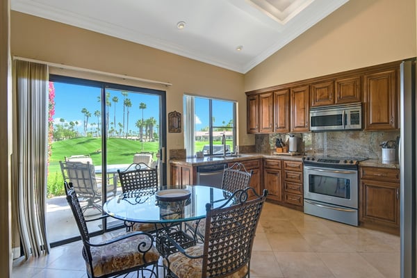 Start your mornings in a sun-drenched kitchen that opens to a private patio overlooking lush manicured greens. Cook, dine, and step outside—all framed by California palms and blue skies.
