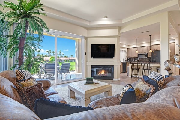 Sink into plush seating beside the glowing fireplace and gaze through the glass doors to your private patio with golf course views.