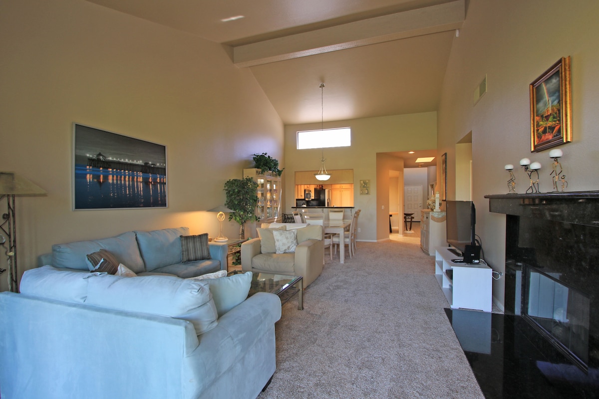 Bright vaulted ceilings and plush seating create your perfect home base. Unwind on the cozy sofas after a day of exploring, then gather at the dining table for a home-cooked meal in the open kitchen beyond.