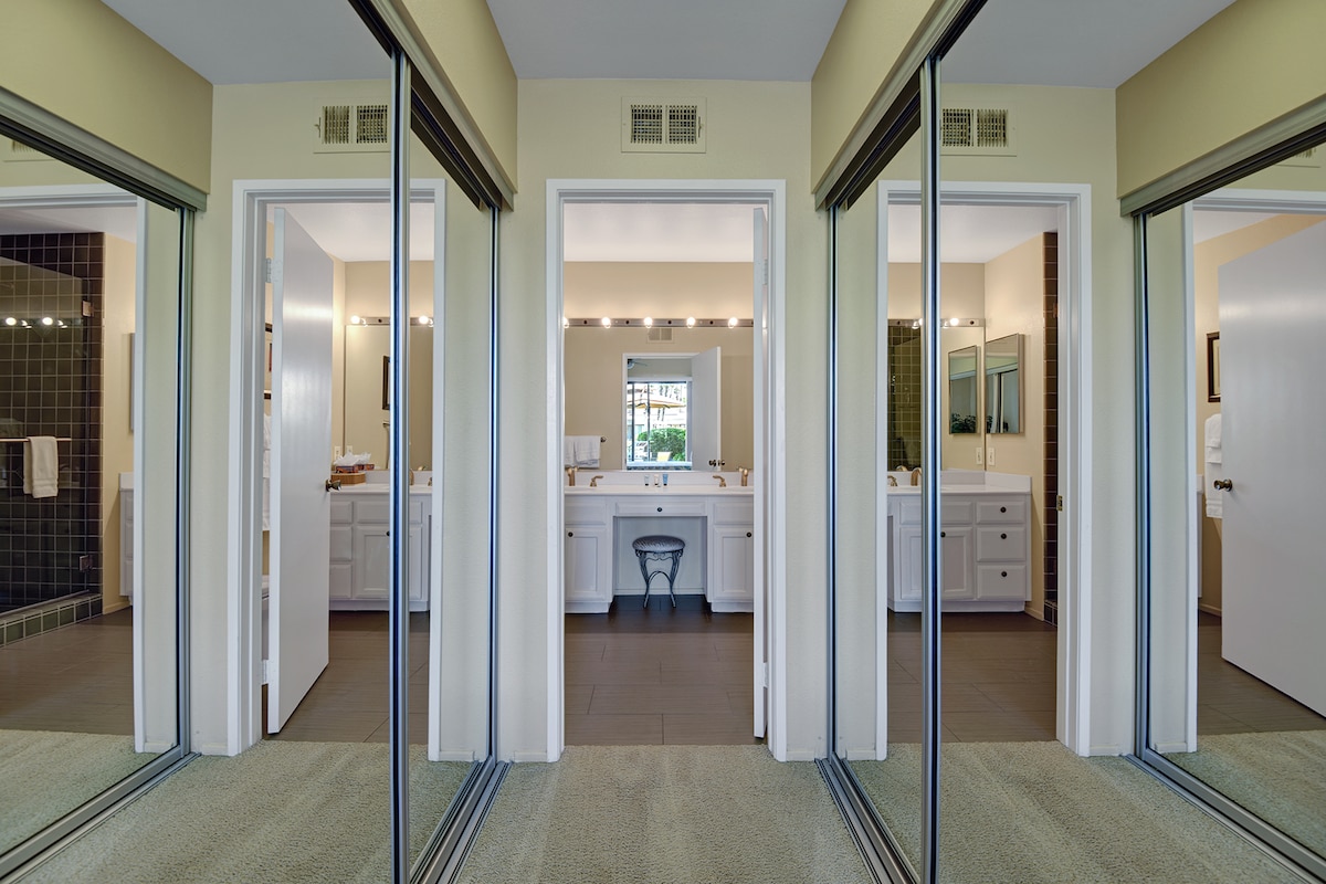 Step through sliding glass doors into your private spa-like bathroom retreat, where dual vanities, elegant lighting, and modern fixtures create the perfect space to unwind.