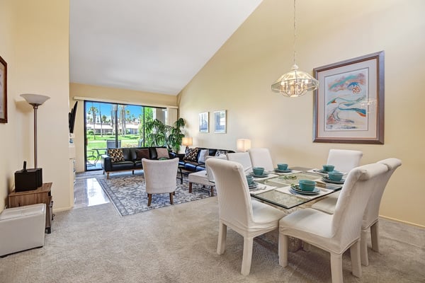 Step into your bright, airy retreat where sunlight pours through the patio doors and vaulted ceilings lift your spirits. Gather around the elegant dining table or unwind in the cozy living area—your perfect home base awaits.