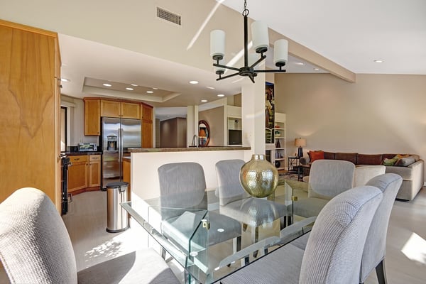 Gather around the elegant glass dining table where your group can share meals together, or unwind in the spacious living area flooded with natural light and vaulted ceilings that create an airy, welcoming retreat.