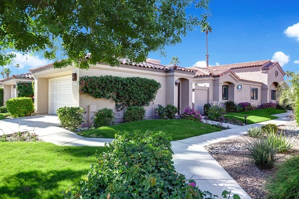 A beautifully manicured property in a peaceful desert setting, with lush landscaping, vibrant blooms, and classic architectural charm—perfect for a relaxing getaway.