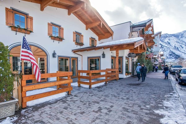 Alpine-style property nestled in a charming mountain village, surrounded by snowy peaks and rustic architecture perfect for a winter getaway.