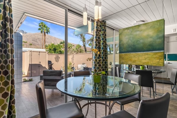 Gather around the sleek glass dining table and enjoy meals with stunning mountain views framing your experience. Modern design meets desert serenity, creating your perfect Palm Springs retreat.