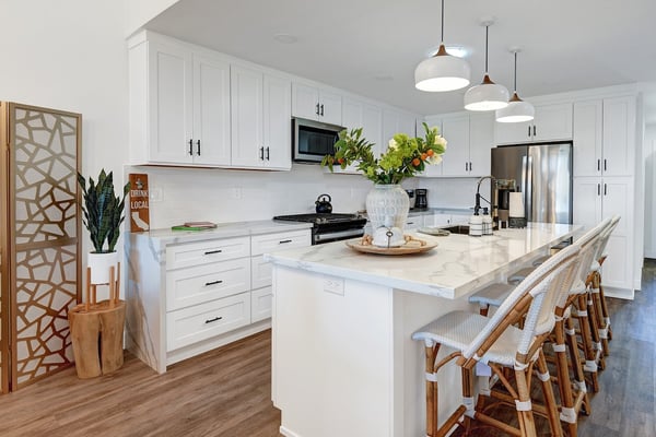 Gather around the spacious island in this bright, fully-equipped kitchen—marble countertops, stainless steel appliances, and coastal charm make meal prep a pleasure.