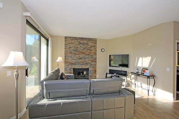 Unwind in your bright living room with a cozy fireplace, sleek modern furnishings, and natural light streaming through the glass doors. Your perfect space to relax after a day of adventure.