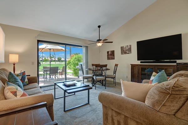Sink into plush seating and let the warm desert sunshine pour through your patio doors, framing lush greens and swaying palms just beyond your private terrace.