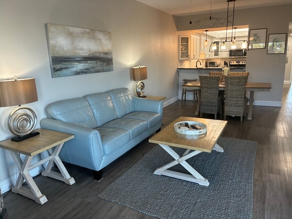 Sink into the plush sofa and enjoy the open flow between your cozy living room and the fully equipped kitchen, where modern style meets coastal comfort—all in your own tranquil getaway.