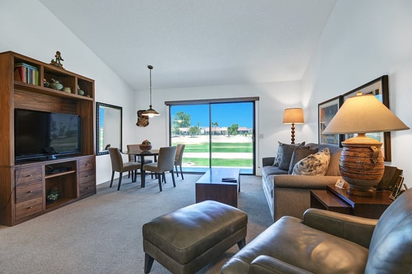 Your bright, open living space flows seamlessly from the cozy sofa to your dining table, with natural light pouring in through large glass doors. Perfect for unwinding or sharing meals together.