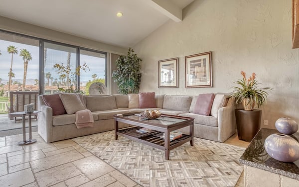 Sink into this comfortable sectional and soak in palm-lined views through floor-to-ceiling windows. Your spacious living room offers a relaxed escape with natural light, vaulted ceilings, and easy access to your private patio.