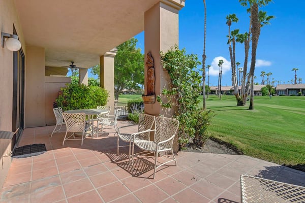 Relax on your private patio with lattice seating overlooking lush fairway greens and swaying palms—a serene retreat perfect for morning coffee or sunset drinks.