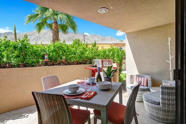 Your private patio overlooks lush gardens and dramatic mountains, perfect for sunny meals and peaceful desert evenings under your own shaded outdoor living space.