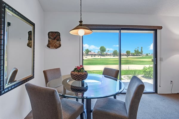 Step into your dining space where sunlight pours through oversized windows revealing lush golf greens beyond. Gather around the sleek table for morning coffee or evening meals, all while enjoying your peaceful view.