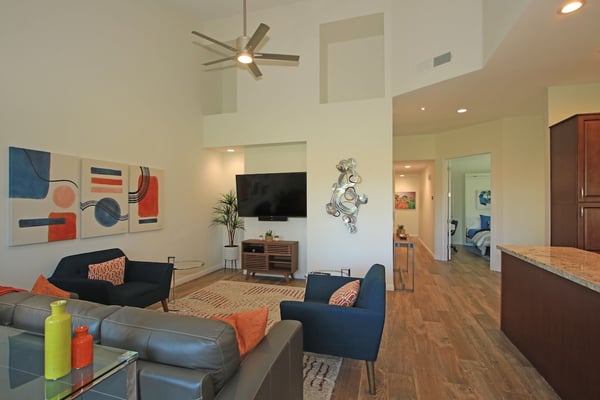 Settle into this spacious, light-filled living area where modern comfort meets vibrant design. High ceilings and contemporary furnishings create the perfect space to unwind after your adventures.
