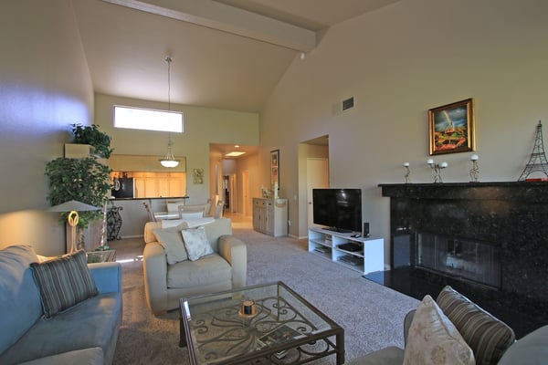 Relax in your spacious, light-filled living room with vaulted ceilings and a cozy fireplace. Unwind on plush sofas after exploring the area, or enjoy a quiet evening by the warmth of the fire.
