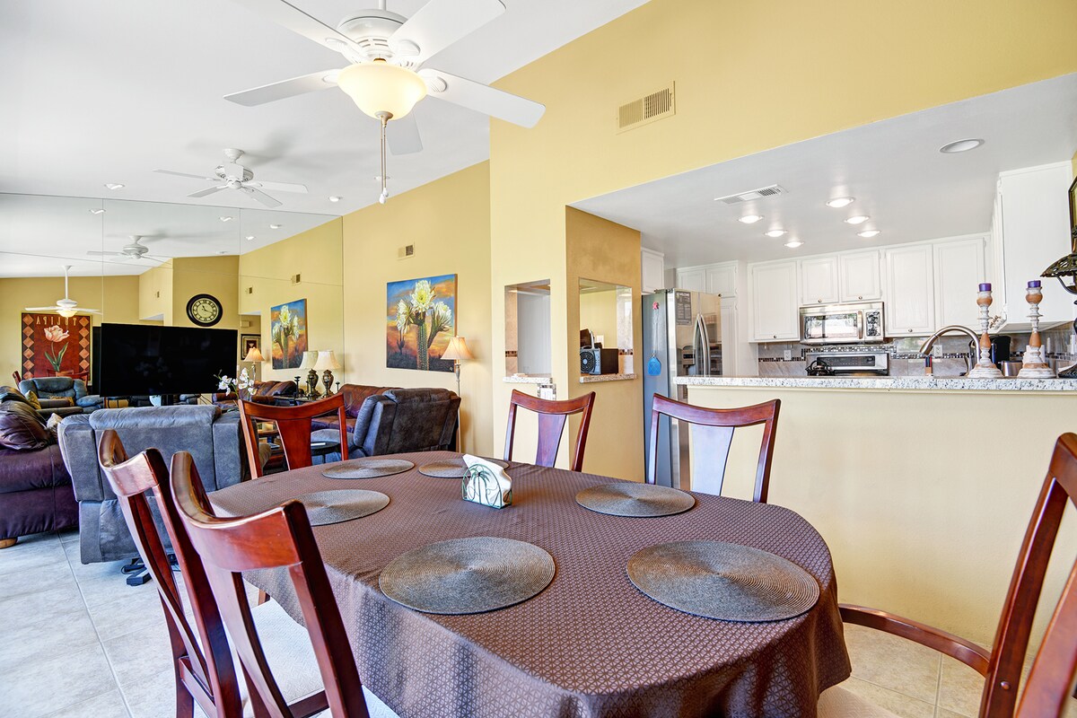 Gather around the spacious dining table for meals and conversation, just steps from your fully equipped kitchen and cozy living area—a bright, open layout perfect for family time.