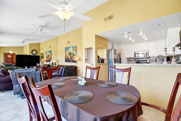Gather around the spacious dining table for meals and conversation, just steps from your fully equipped kitchen and cozy living area—a bright, open layout perfect for family time.
