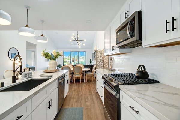 You'll love cooking in this bright, modern kitchen with marble countertops, sleek appliances, and plenty of space to prepare meals while enjoying the open flow into your dining area.
