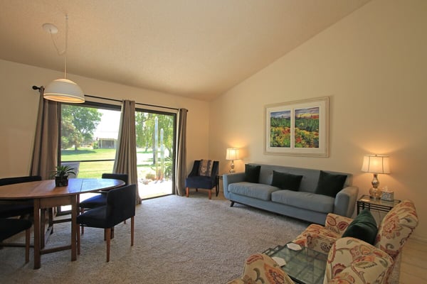 Relax in your bright, open living space with plush seating, a cozy dining nook, and sliding glass doors that open to a peaceful green lawn—perfect for unwinding after a day of exploring.