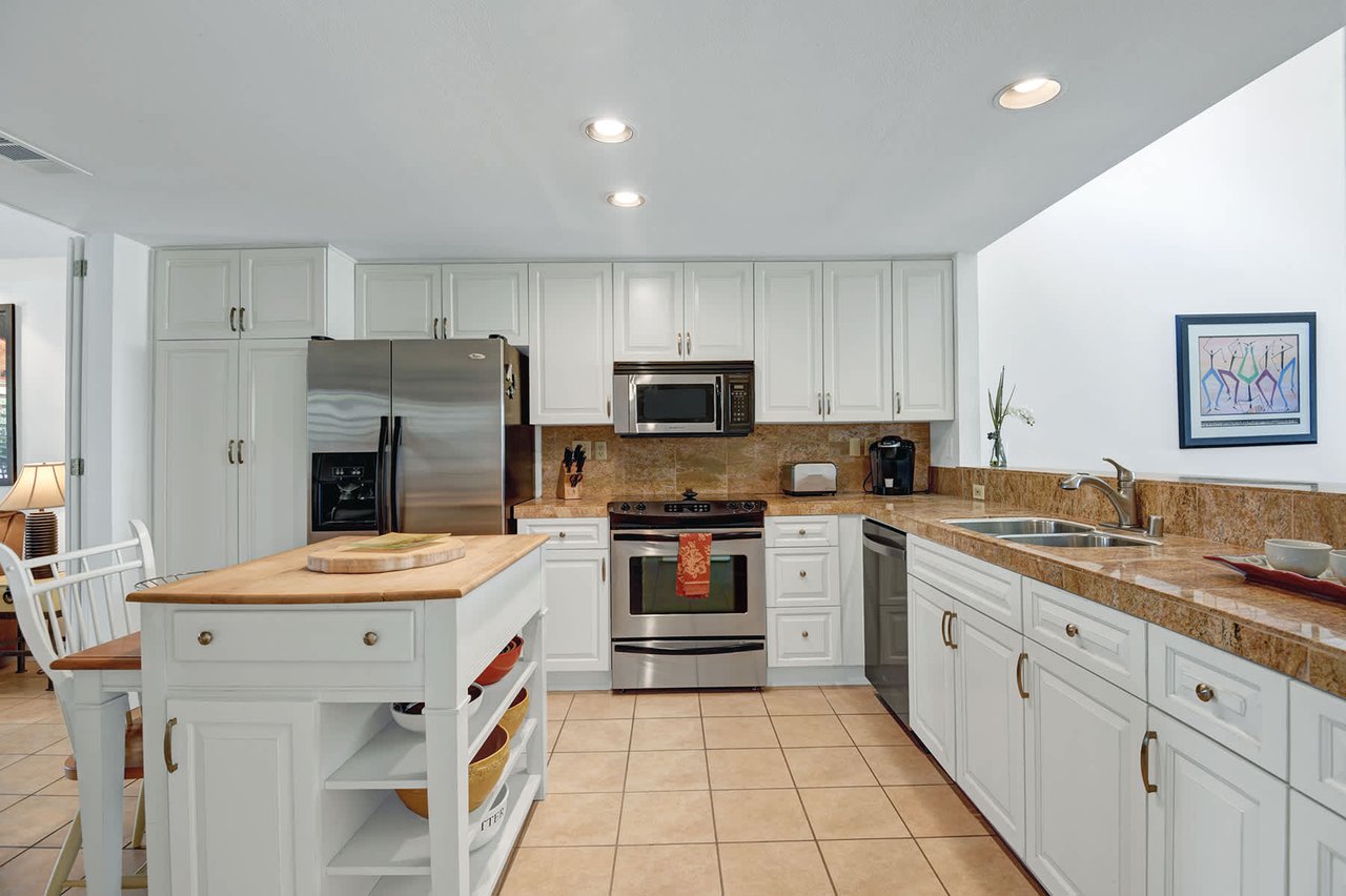 Step into your bright, fully-equipped kitchen where preparing meals becomes a joy. Sleek appliances, ample counter space, and a charming island invite you to cook and gather together.
