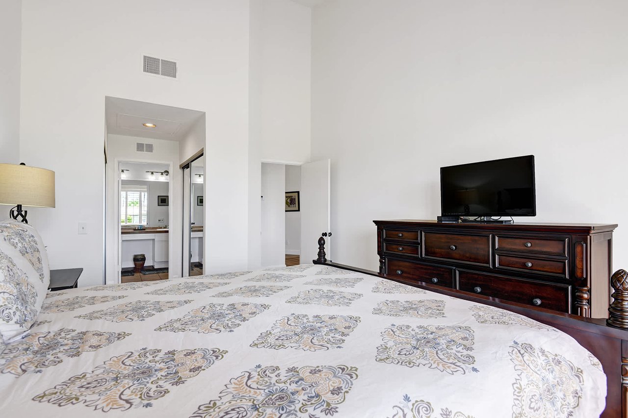 Rest easy in your serene bedroom with a plush bed and elegant dark wood furnishings. The en-suite bathroom is just steps away, and you'll enjoy climate-controlled comfort throughout your stay.