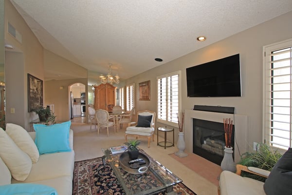 Settle into this bright, open living space where a cozy fireplace and natural light create the perfect backdrop for your vacation relaxation.