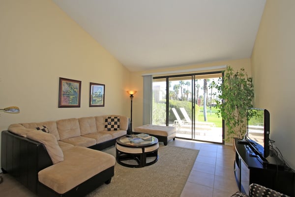 Settle into this cozy living room where soft seating invites you to unwind after a day of desert adventures. Step through your private patio door to bask in warm sunshine and lush palm tree views.