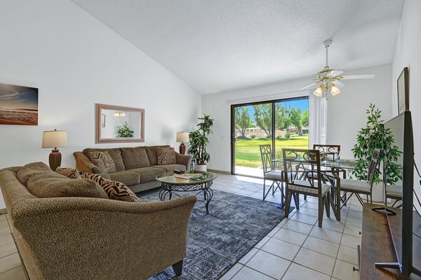 Step into your bright, welcoming living space where comfort meets style. Relax on plush seating, enjoy meals at the dining table, and take in lovely green views through your glass doors.