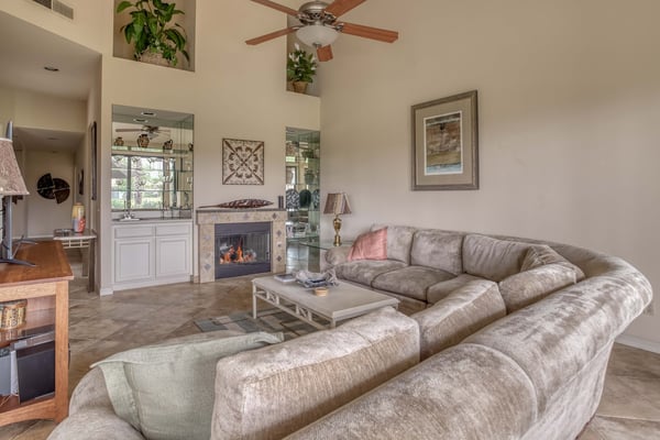 Settle into your spacious living room, where a crackling fireplace and soaring ceilings create an inviting atmosphere for relaxing evenings with family and friends.