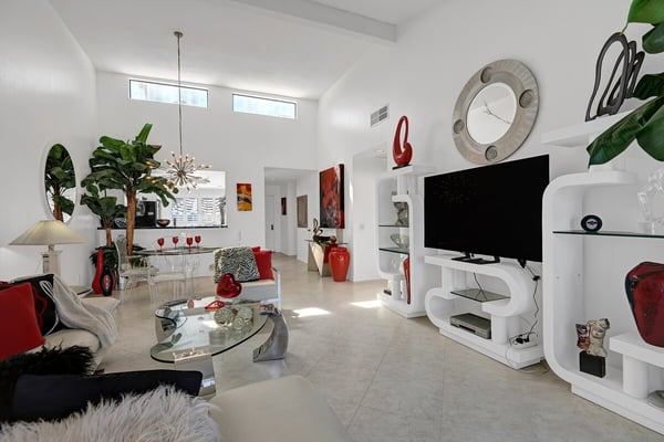 Sink into plush seating under soaring vaulted ceilings, where natural light pours in and vibrant accents invite you to relax in style. Modern design meets cozy comfort in your stunning retreat.