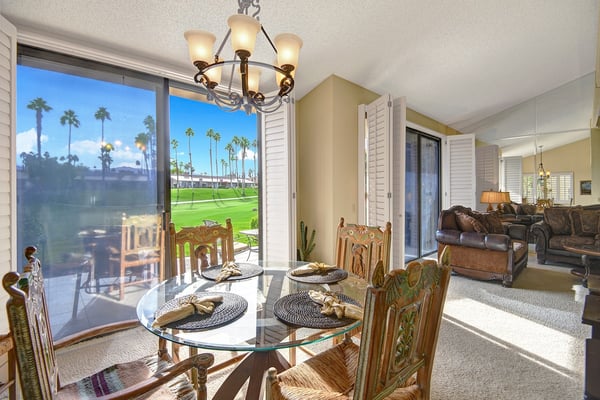 Step into your sunlit dining space, where meals come alive with views of emerald greens and swaying palms beyond the glass. Open the doors to connect inside and out, letting natural beauty frame every moment.