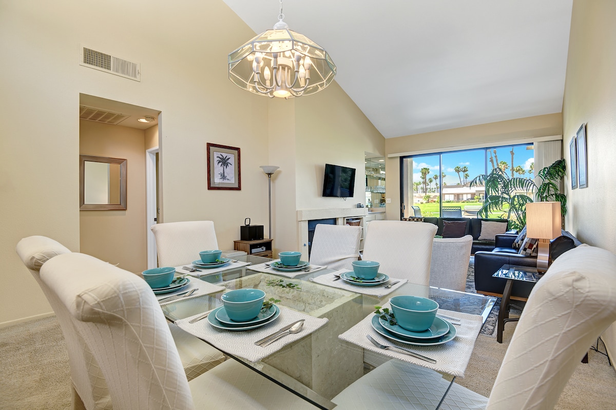 Gather around this elegant dining table where your mornings begin with coffee and conversation. Through the window, genuine palm trees sway in the California sunshine—inviting you to savor every meal in this light-filled, welcoming space.