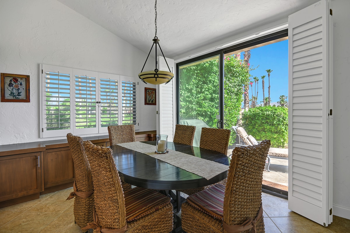 Your bright dining area opens onto a private outdoor space framed by lush greenery and swaying palms. Gather around the table with friends and family, enjoying natural light and easy indoor-outdoor flow.