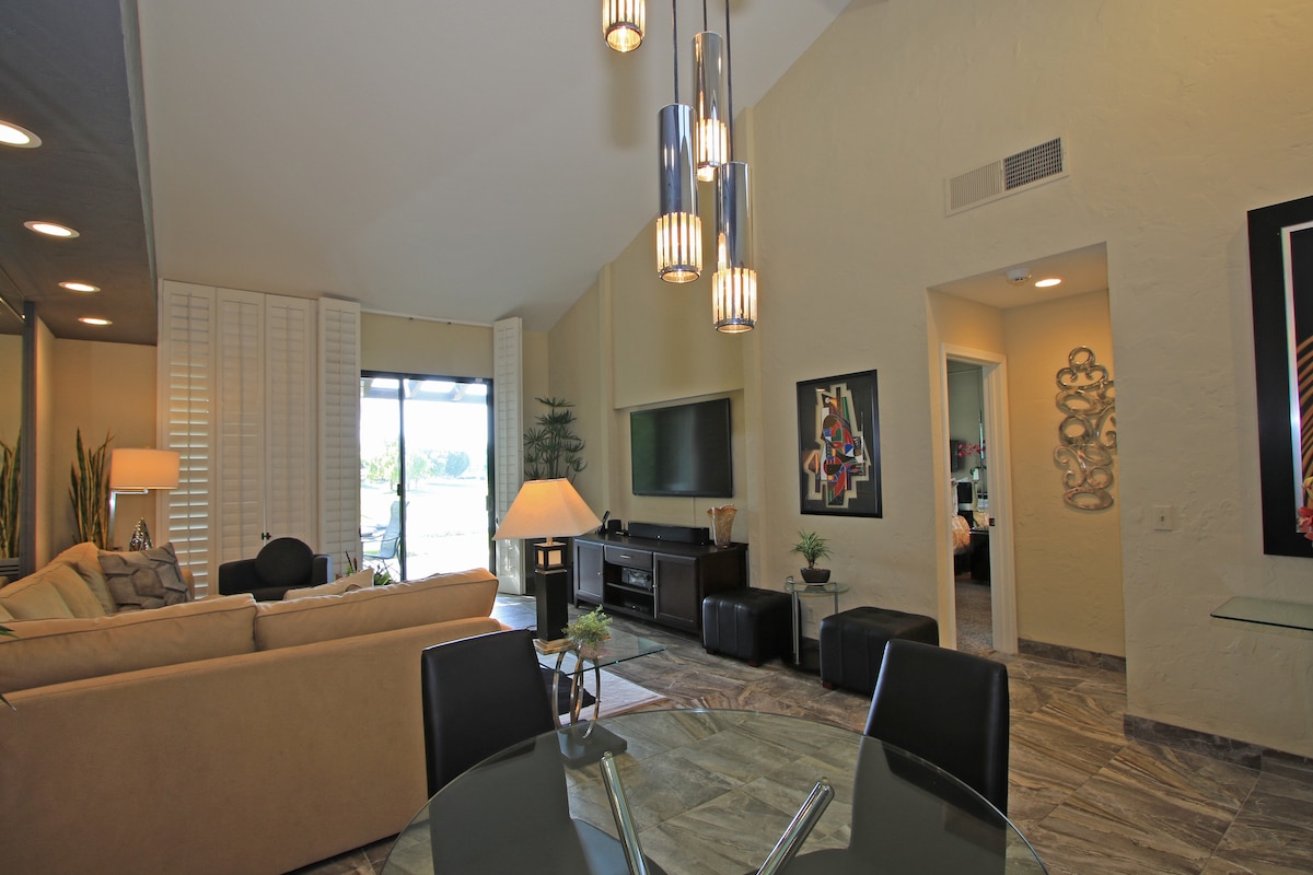 Relax in this open, sun-filled living space with soaring ceilings and modern pendant lighting. Unwind on plush seating while you enjoy your favorite shows or gather around the sleek dining table for meals together.