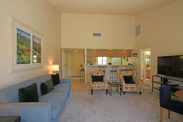 Unwind in your spacious living area with soaring ceilings and comfortable seating that flows seamlessly into the open kitchen—perfect for relaxing after a day exploring the desert.