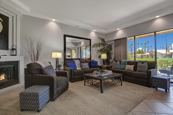 Sink into plush sofas in your sunlit living room, where warm firelight meets California sunshine streaming through glass doors. Your perfect space to unwind after exploring the desert.