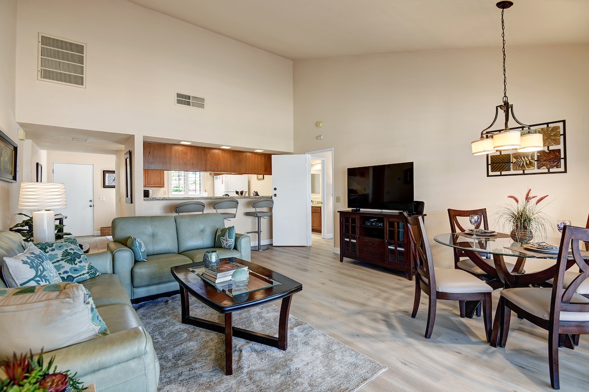 Picture yourself relaxing in this bright, open-concept living space with soaring ceilings and coastal-inspired decor. Unwind on the plush sectional, gather around the dining table, or catch up on your favorite shows—everything you need is right here.