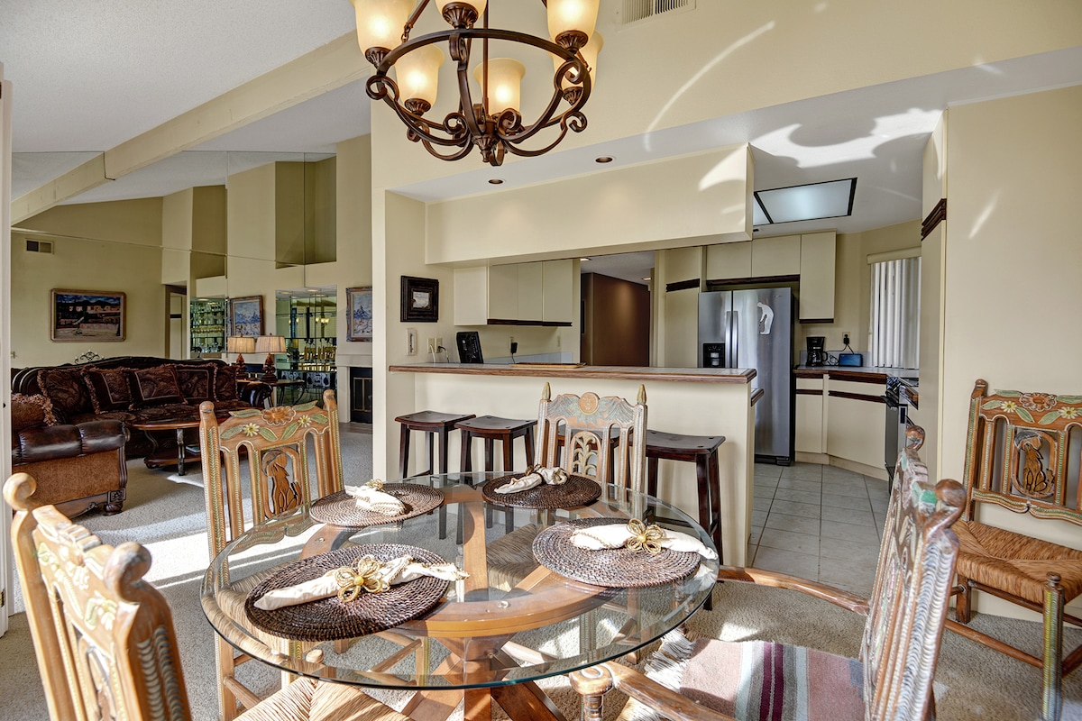 Step into your spacious open-concept living area where elegant details meet everyday comfort. Gather around the dining table or sink into the plush leather seating, all bathed in warm natural light under soaring ceilings.