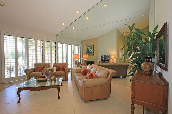 Sink into plush seating and let natural light fill your spacious living area, where elegant furnishings and high ceilings create the perfect retreat for relaxation.