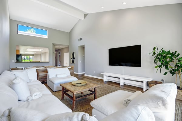 Unwind in your light-filled living space, where soaring vaulted ceilings and plush seating create the perfect backdrop for movie nights or quiet afternoons with loved ones.