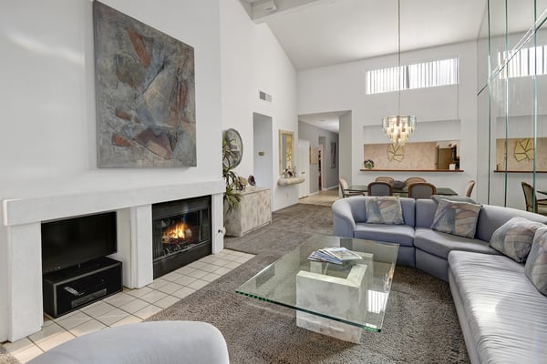 Your bright, spacious living area welcomes you with soaring ceilings and natural light streaming through high windows. Sink into plush seating by the cozy fireplace, perfect for relaxing evenings after exploring.